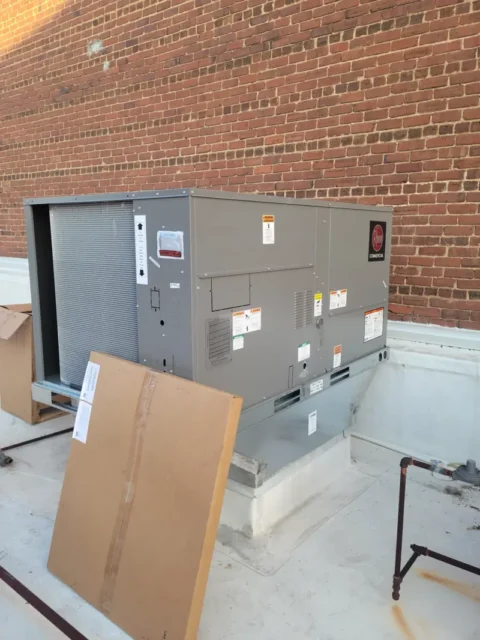 a large grey box next to a brick wall a Commercial HVAC Services HVAC Installation